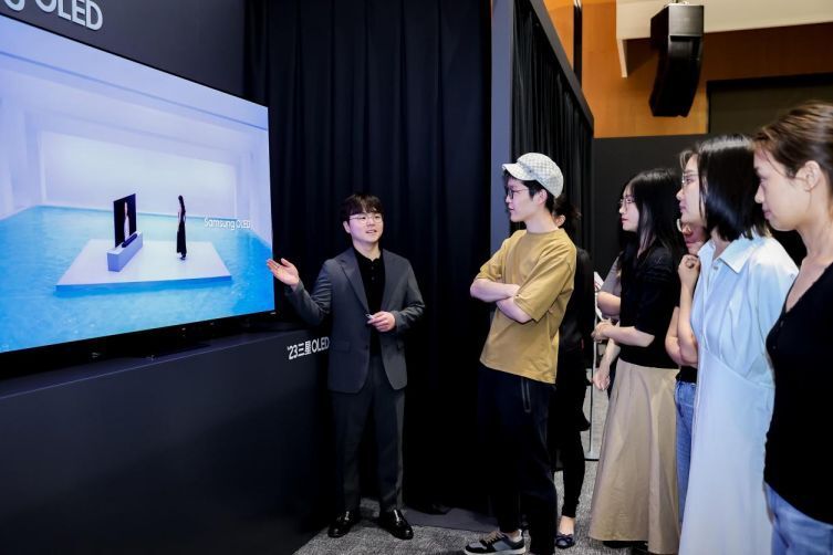 A group of people standing in front of a screen Description automatically generated with medium confidence